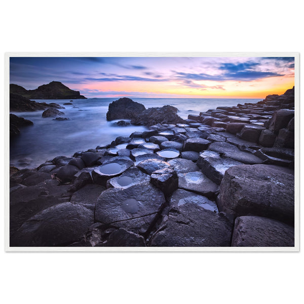 Framed art print of a breathtaking sunset at Giant's Causeway. Features iconic basalt columns against a warm, colorful sky. Perfect for adding sophistication and natural beauty to any home or office decor. Ideal for nature and art enthusiasts.